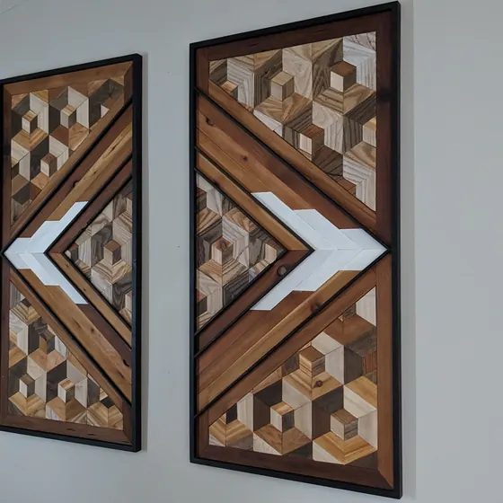 Two panels of geometric wood wall art hanging on a wall