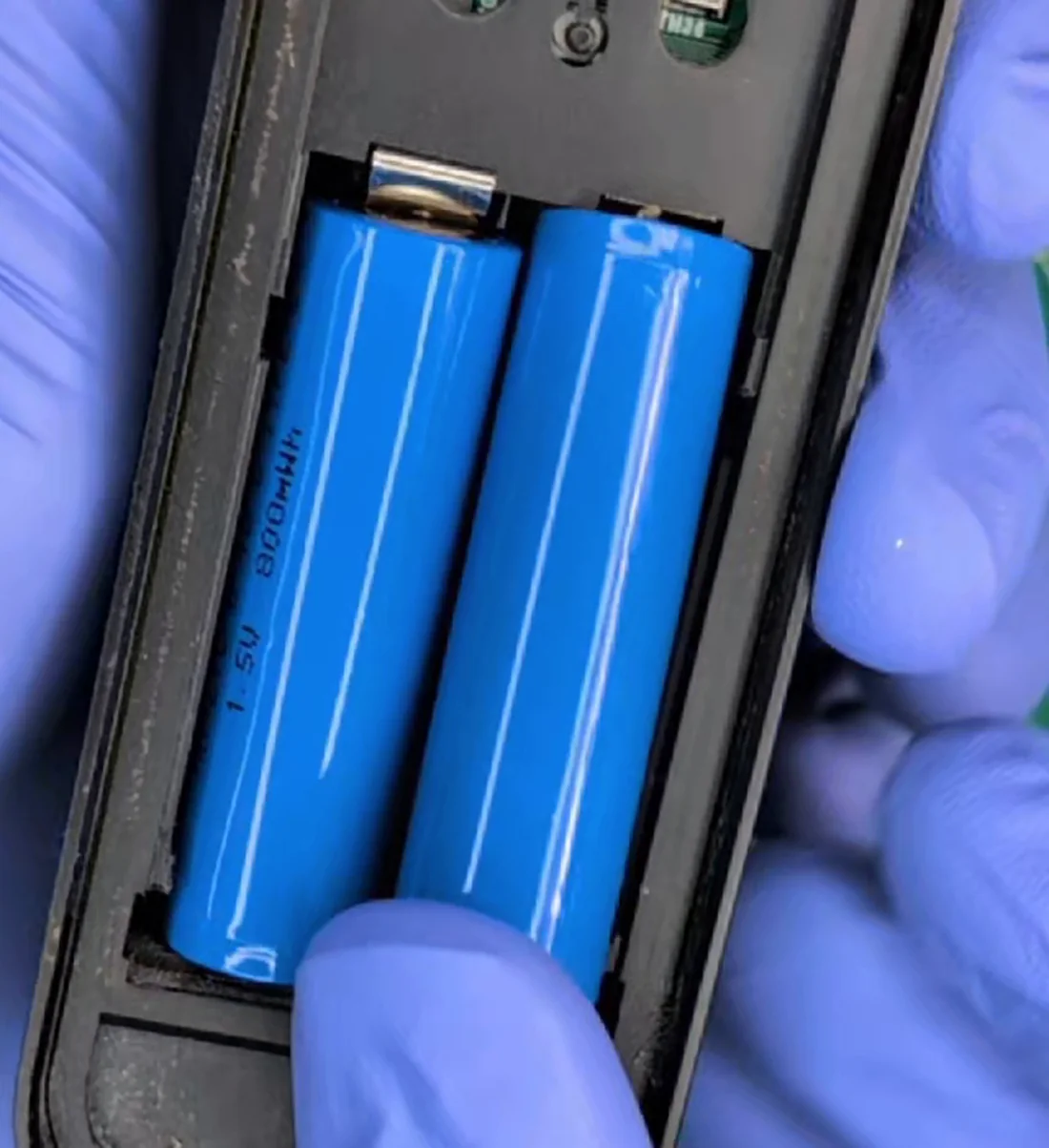 Two Winterwatt cells seated in a trail camera's battery bay